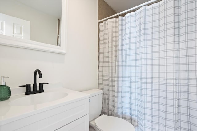 bathroom with vanity, a shower with shower curtain, and toilet