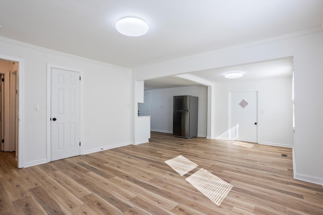 unfurnished room featuring ornamental molding and light wood-type flooring