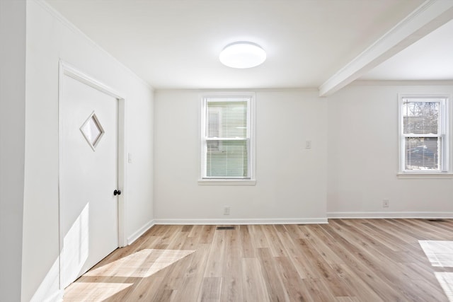 empty room featuring crown molding, a healthy amount of sunlight, and light hardwood / wood-style flooring