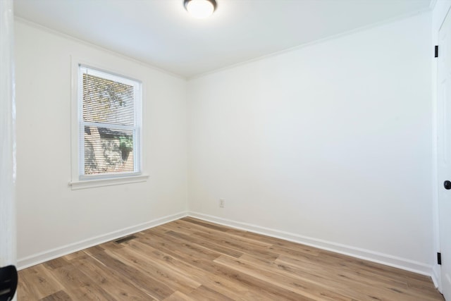 unfurnished room featuring ornamental molding and light hardwood / wood-style floors