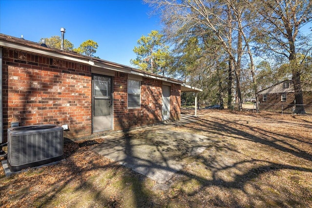 rear view of property with central AC unit and a patio