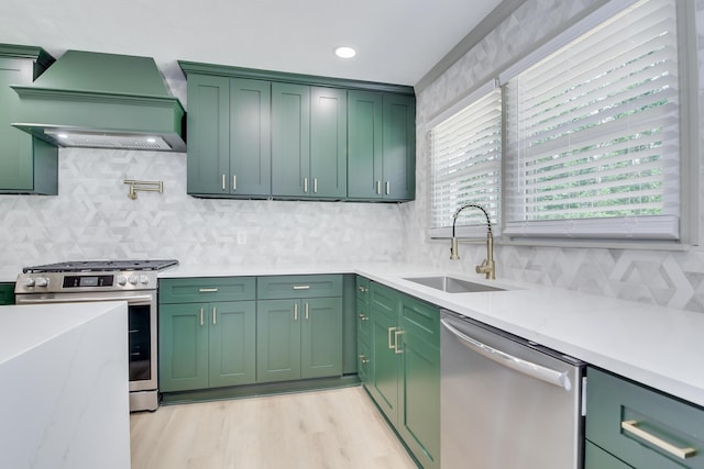 kitchen featuring a sink, stainless steel appliances, decorative backsplash, custom exhaust hood, and green cabinets