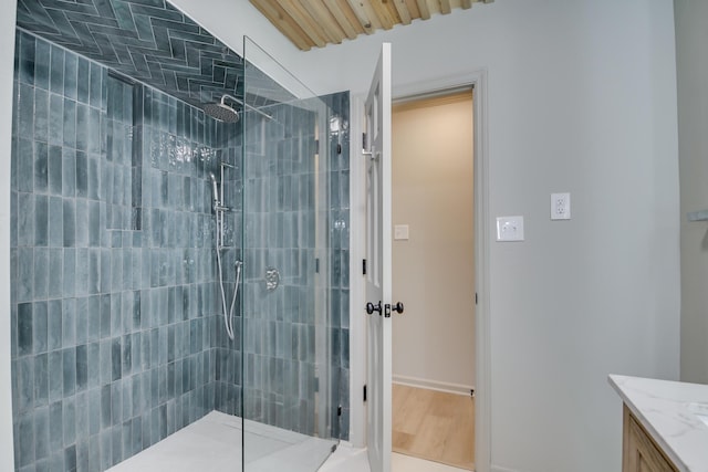 full bath featuring vanity, a walk in shower, and baseboards