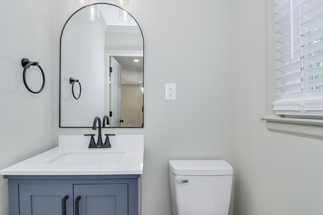 half bathroom with vanity and toilet