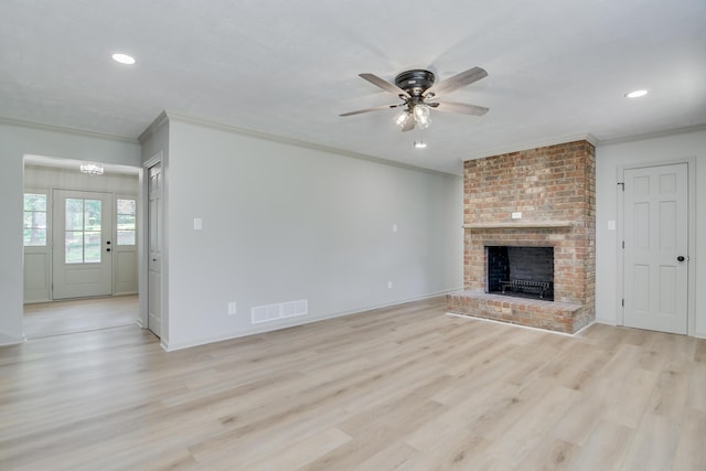 unfurnished living room with crown molding, a ceiling fan, light wood-style floors, and a fireplace