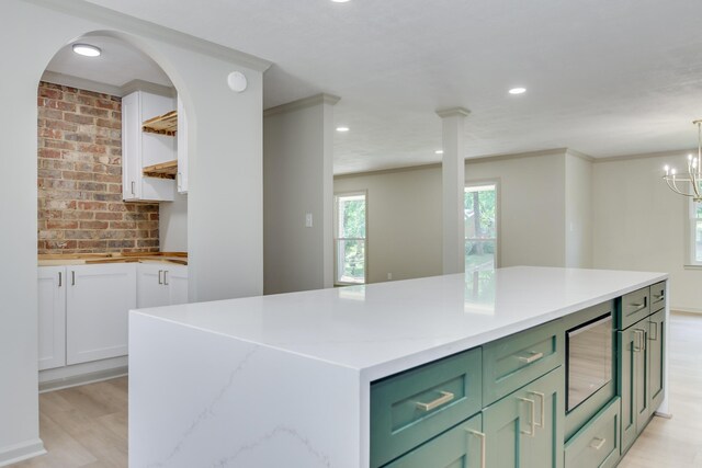 kitchen with open shelves, green cabinetry, a center island, recessed lighting, and light wood-type flooring