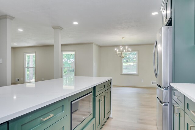 kitchen with built in microwave, light countertops, green cabinets, freestanding refrigerator, and a chandelier
