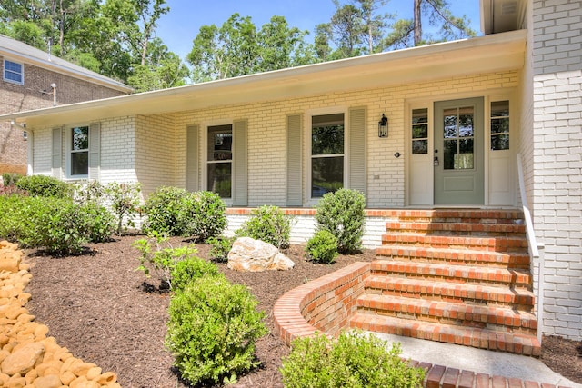 entrance to property with brick siding and a porch