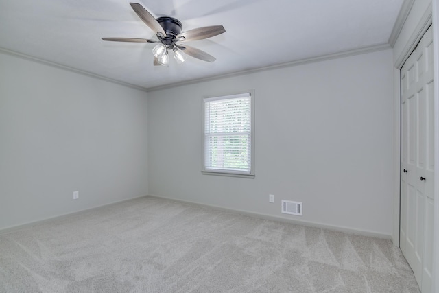unfurnished bedroom with ornamental molding, carpet, a closet, and visible vents