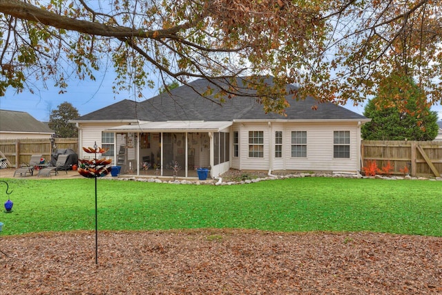 rear view of house featuring a yard, a patio, and a sunroom