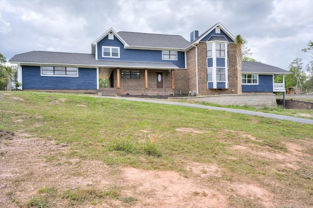 1543 Wrens Hwy, Thomson, GA 30824 - view of front of home featuring brick siding, a front lawn, covered porch, and a chimney