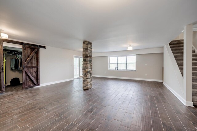 1543 Wrens Hwy, Thomson, GA 30824 - unfurnished living room with stairway, baseboards, ornate columns, and a barn door