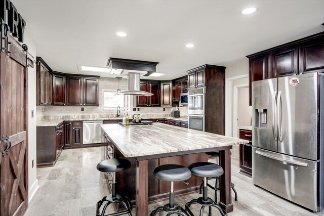 1543 Wrens Hwy, Thomson, GA 30824 - kitchen featuring a breakfast bar area, stainless steel appliances, decorative backsplash, and island exhaust hood
