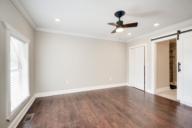 1543 Wrens Hwy, Thomson, GA 30824 - unfurnished bedroom featuring baseboards, ornamental molding, a barn door, and visible vents