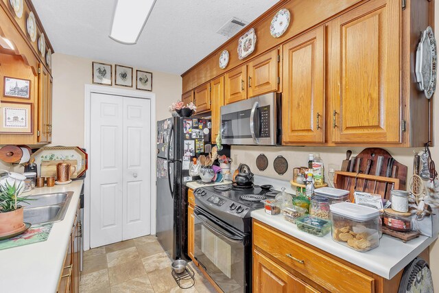 16 Cardinal Ln, North Augusta, SC 29841 - kitchen with black appliances, light countertops, brown cabinetry, and a sink