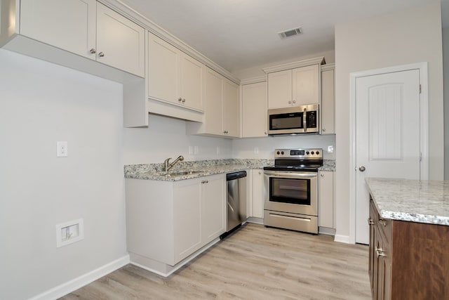 344 Bordeaux Dr, Thomson, GA 30824 - kitchen with appliances with stainless steel finishes, sink, light stone counters, and light hardwood / wood-style flooring