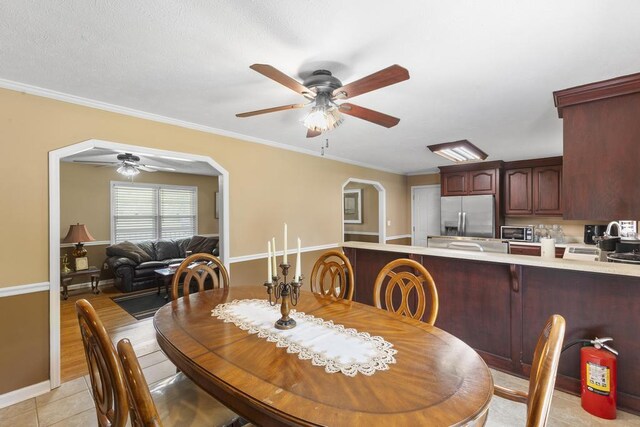 460 Archie Ware Rd, Ridge Spring, SC 29129 - dining room featuring ceiling fan, arched walkways, ornamental molding, light tile patterned floors, and baseboards