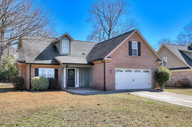 traditional home featuring brick siding, driveway, a front lawn, and roof with shingles