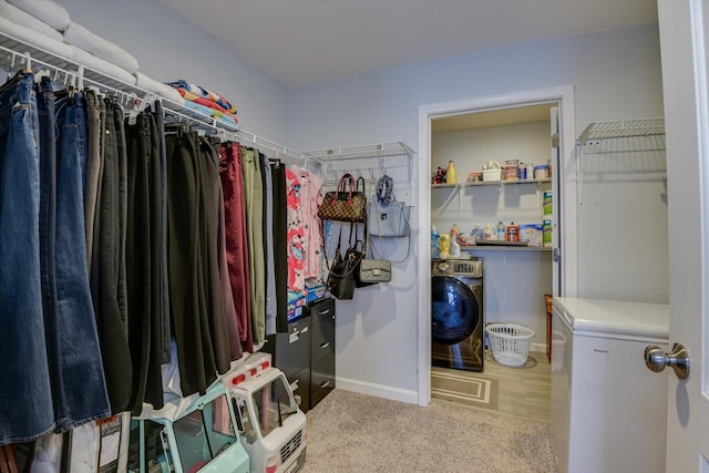 spacious closet featuring washer / dryer and carpet flooring