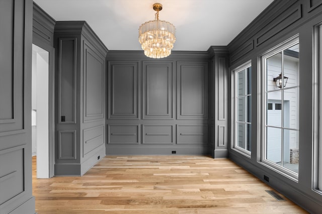 845 Audubon Way, Evans, GA 30809 - unfurnished dining area with a chandelier, a decorative wall, and light wood-style floors