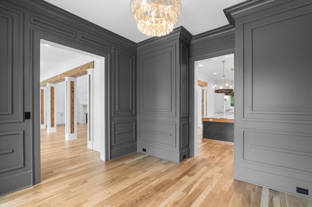 845 Audubon Way, Evans, GA 30809 - unfurnished dining area featuring a chandelier, crown molding, a decorative wall, and light wood finished floors