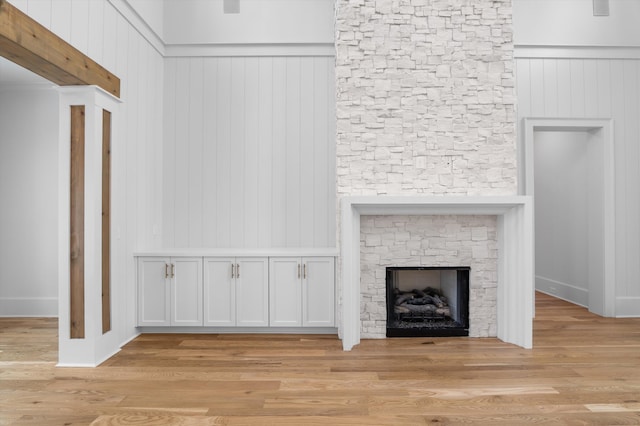 845 Audubon Way, Evans, GA 30809 - unfurnished living room featuring light wood-type flooring, a stone fireplace, and wood walls