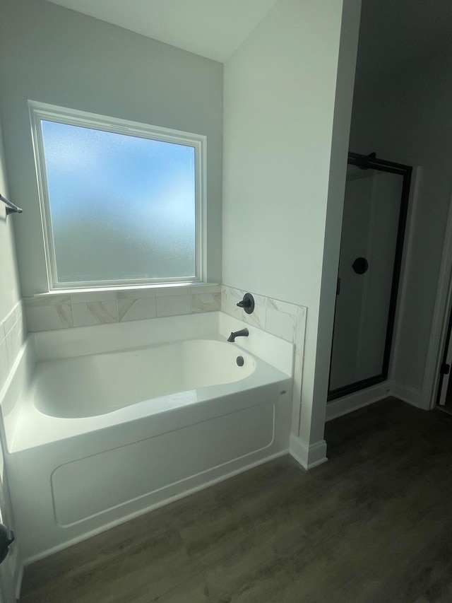 bathroom featuring plus walk in shower and wood-type flooring