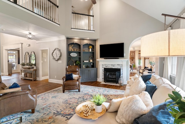 460 Armstrong Way, Evans, GA 30809 - living area with wood finished floors, a tiled fireplace, high vaulted ceiling, and arched walkways