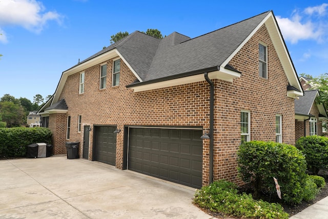 460 Armstrong Way, Evans, GA 30809 - view of side of home with a shingled roof, brick siding, an attached garage, and driveway