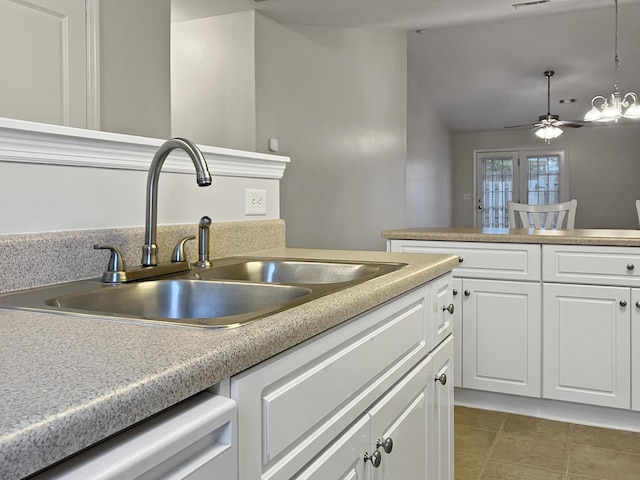 kitchen with a sink, dishwasher, light tile patterned floors, white cabinets, and ceiling fan