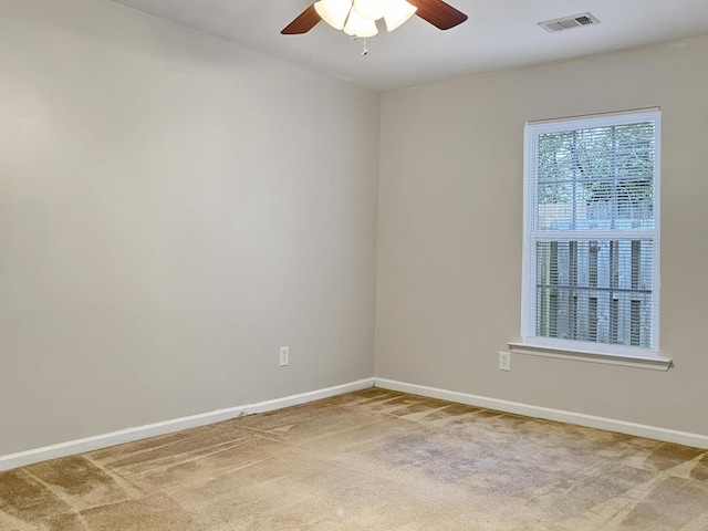 unfurnished room featuring light colored carpet, baseboards, ceiling fan, and visible vents