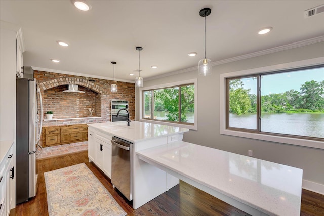 118 Lake Bluff Dr, Waynesboro, GA 30830 - kitchen featuring appliances with stainless steel finishes, a kitchen island with sink, white cabinetry, crown molding, and light stone counters