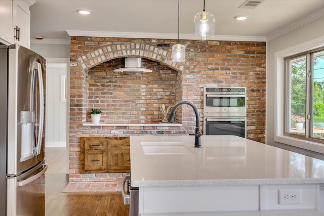 118 Lake Bluff Dr, Waynesboro, GA 30830 - kitchen featuring stainless steel appliances, ornamental molding, wood finished floors, light stone counters, and decorative light fixtures