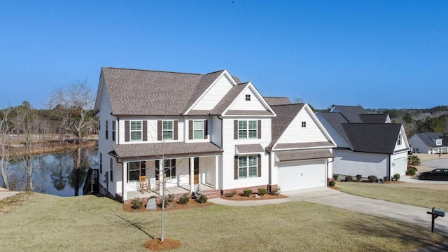 view of front facade featuring driveway, a garage, a water view, covered porch, and a front yard