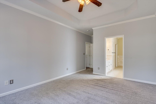 spare room featuring crown molding, light carpet, ceiling fan, and a tray ceiling