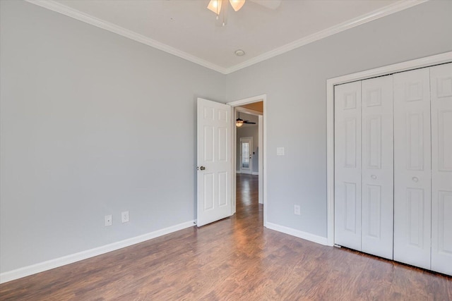 unfurnished bedroom with a closet, ornamental molding, dark hardwood / wood-style floors, and ceiling fan