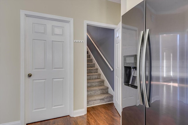 stairway with hardwood / wood-style flooring and ornamental molding