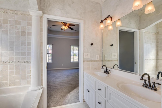 bathroom with decorative columns, a bathing tub, vanity, and ceiling fan