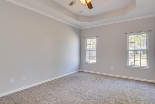 carpeted spare room featuring crown molding, ceiling fan, and a tray ceiling