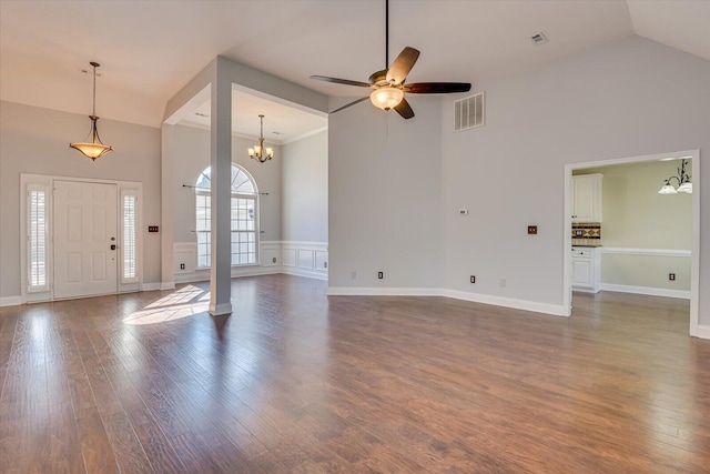 foyer entrance featuring dark hardwood / wood-style flooring, ceiling fan with notable chandelier, and high vaulted ceiling