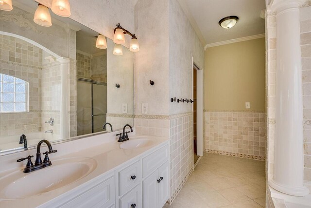 bathroom with tile patterned floors, separate shower and tub, tile walls, ornamental molding, and decorative columns