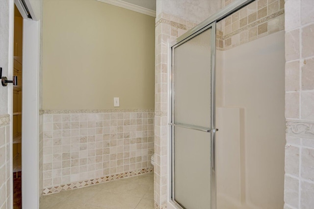 bathroom featuring tile walls, crown molding, tile patterned floors, and walk in shower