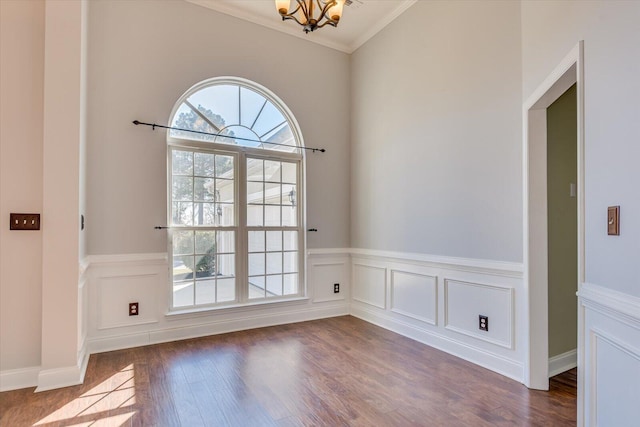 interior space featuring hardwood / wood-style flooring, ornamental molding, and an inviting chandelier