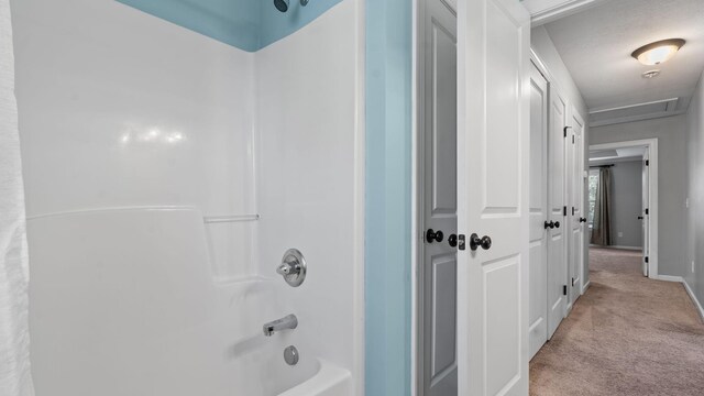 bathroom featuring shower / bathing tub combination and a textured ceiling