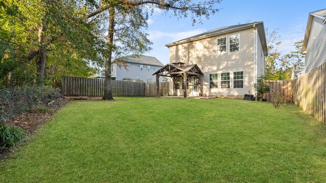 rear view of property featuring a gazebo and a yard