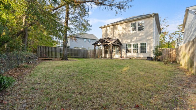 rear view of house featuring a lawn and a gazebo