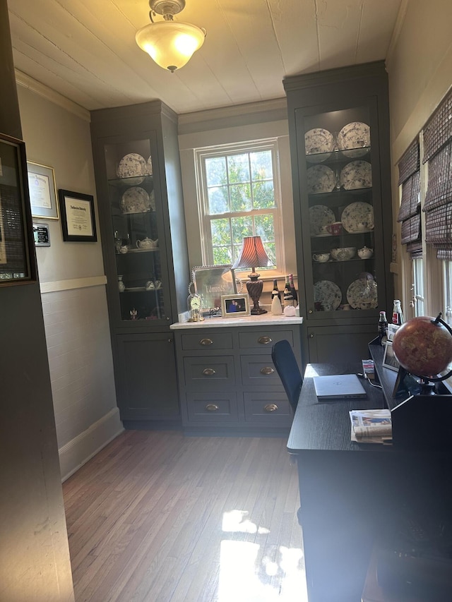 office area with light wood-type flooring and crown molding
