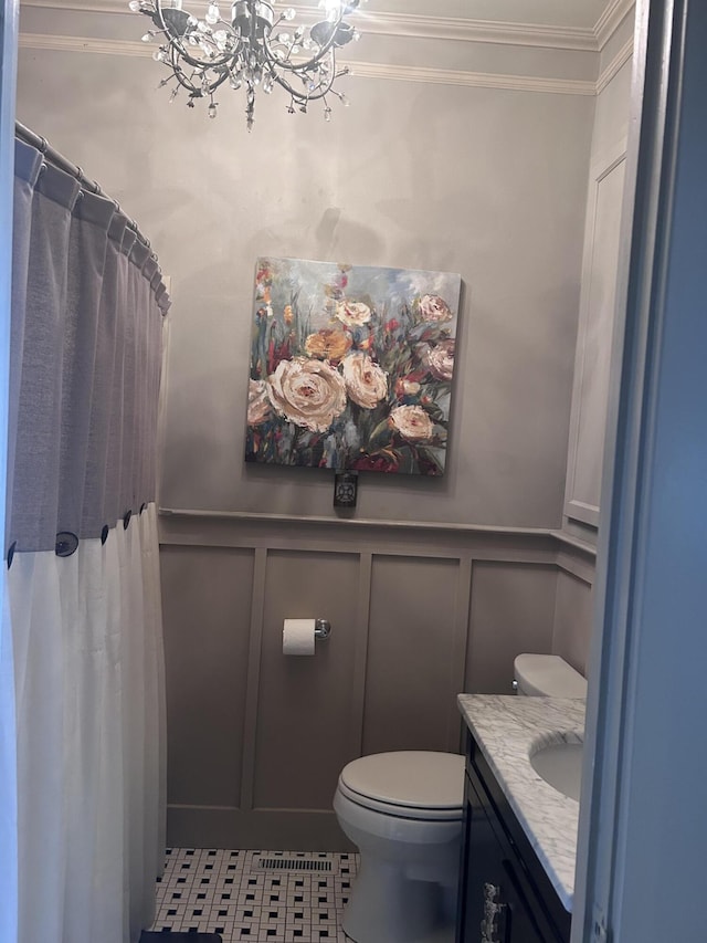 bathroom featuring a decorative wall, tile patterned floors, a chandelier, toilet, and ornamental molding