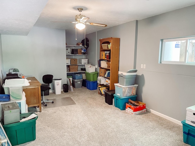 carpeted home office with a textured ceiling and ceiling fan