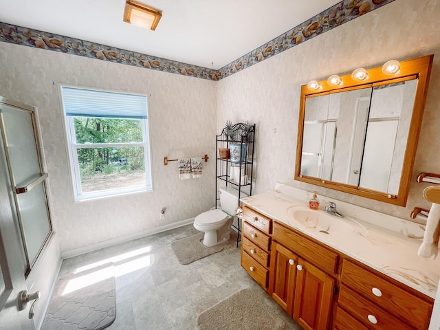 bathroom with toilet, shower / bath combination with glass door, vanity, and baseboards